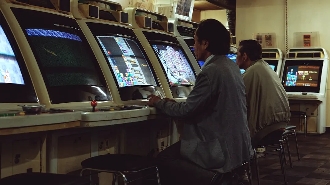 a man playing a video game in front of a row of slot machines