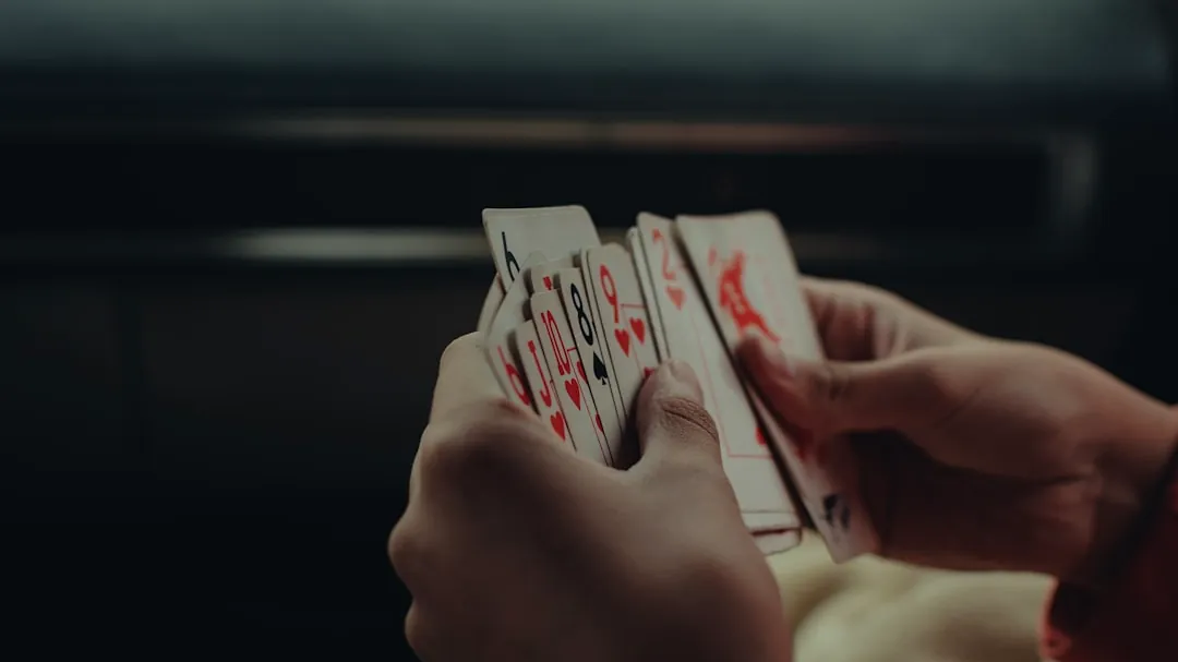 a person holding playing cards in their hands