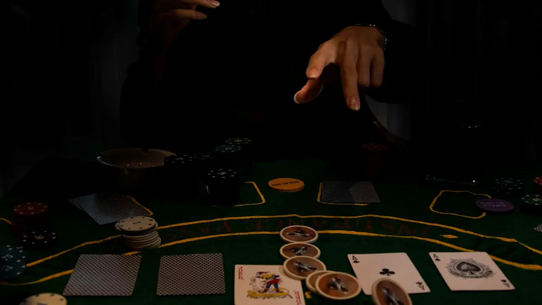 a person sitting at a table with cards and chips